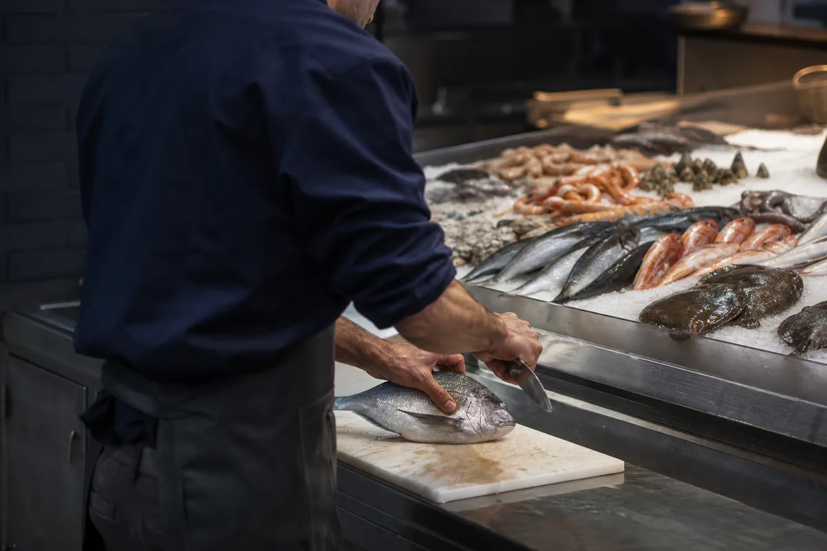 Poissonnier préparant des poissons frais sur un étal